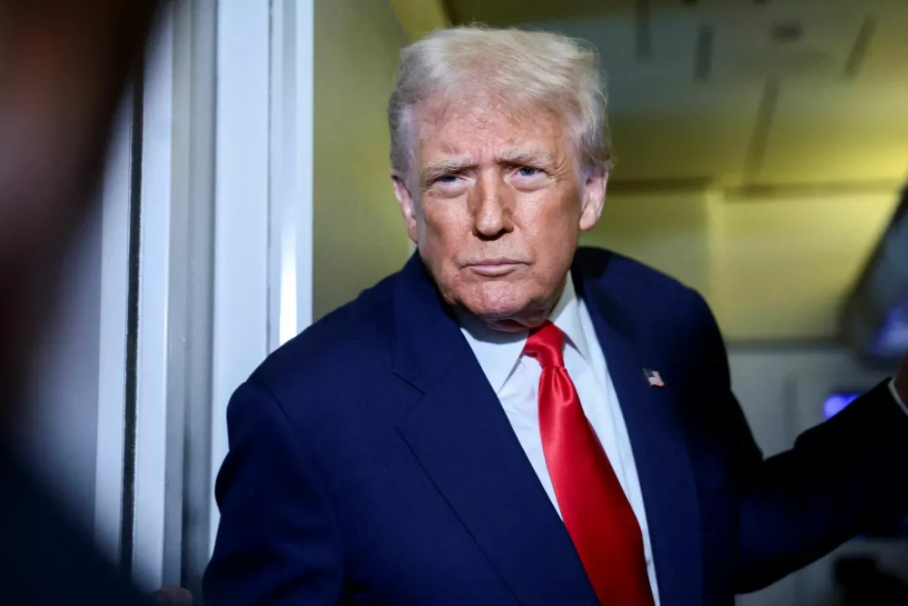 FILE PHOTO: U.S. President Donald Trump speaks to members of the media on board Air Force One en route to the U.S., October 30, 2025. REUTERS/Evelyn Hockstein/File Photo