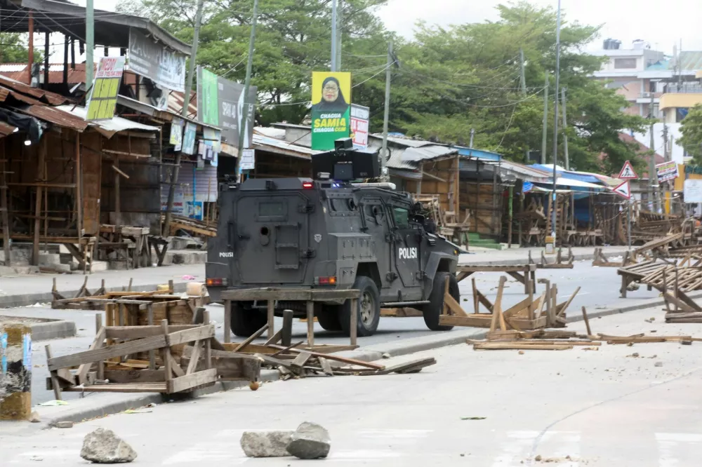 A Tanzanian police vehicle drives along a road barricaded by demonstrators during violent protests that marred the election following the disqualification of the two leading opposition candidates in Dar es Salaam, Tanzania, October 29, 2025. REUTERS/Onsase Ochando