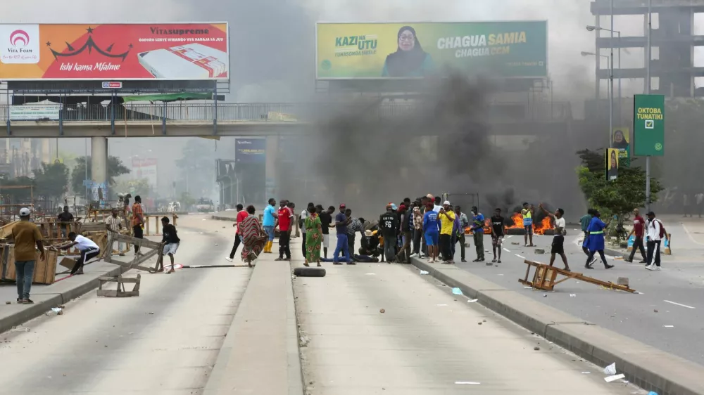 SENSITIVE MATERIAL. THIS IMAGE MAY OFFEND OR DISTURB. Demonstrators attend to a man shot and killed during violent protests that marred the election following the disqualification of the two leading opposition candidates in Dar es Salaam, Tanzania, October 29, 2025. REUTERS/Onsase Ochando