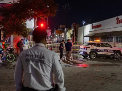 Policeman stands near a convenience store destroyed by a fire in Hermosillo, Sonora state, Mexico, Saturday, Nov. 1, 2025. (AP Photo/Abraham Tellez)