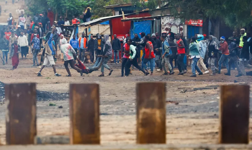 SENSITIVE MATERIAL. THIS IMAGE MAY OFFEND OR DISTURB  Demonstrators carry the dead body of a man killed during a protest a day after a general election marred by violent demonstrations over the exclusion of two leading opposition candidates at the Namanga One-Post Border crossing point between Kenya and Tanzania, as seen from Namanga, Kenya October 30, 2025. REUTERS/Thomas Mukoya