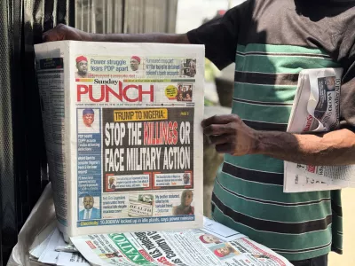 A vendor sells local newspapers with headlines referring to US President Donald Trump's comments about Nigeria, on the street of Lagos, Nigeria, Sunday, Nov. 2, 2025. (AP Photo/Sunday Alamba)