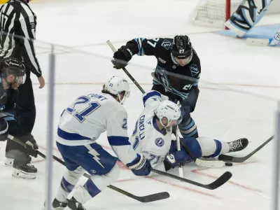 Tampa Bay Lightning center Anthony Cirelli (71) fights for the puck against Utah Mammoth center Barrett Hayton (27) during the third period of an NHL hockey game Sunday, Nov. 2, 2025, in Salt Lake City. (AP Photo/Melissa Majchrzak)