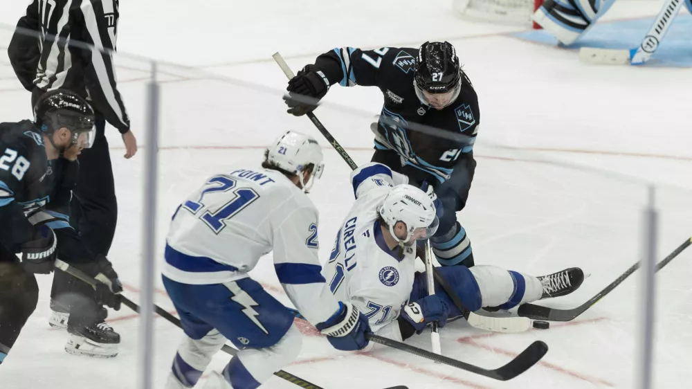 Tampa Bay Lightning center Anthony Cirelli (71) fights for the puck against Utah Mammoth center Barrett Hayton (27) during the third period of an NHL hockey game Sunday, Nov. 2, 2025, in Salt Lake City. (AP Photo/Melissa Majchrzak)