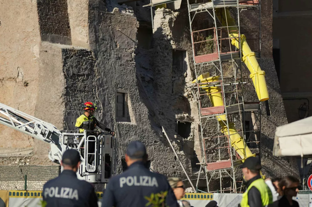 Firefighters work on a medieval tower Torre dei Conti near the Roman Forum after it had partially collapsed during renovation works, meters away from the Colosseum in Rome, Monday, Nov. 3, 2025. (AP Photo/Andrew Medichini)
