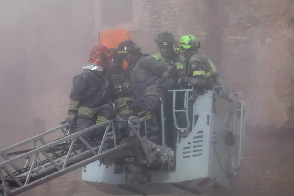 Dust rises following collapses of parts of the Torre dei Conti tower while members of emergency services work at the scene, near Via dei Fori Imperiali, near the Colosseum, in Rome, Italy, November 3, 2025. REUTERS/Remo Casilli