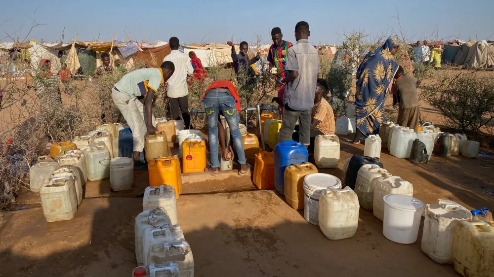 Sudanese men who fled el-Fasher city, after Sudan's paramilitary forces killed hundreds of people in the western Darfur region, collect water at a camp in Tawila, Sudan, Saturday, Nov. 1, 2025. (AP Photo/Mohammed Bakry)