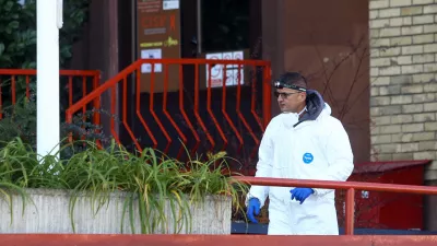 A forensic policeman stands in front of a retirement home following a major fire that killed at least 11 people, in Tuzla, Bosnia, Tuesday, Nov. 5, 2025. (AP Photo)