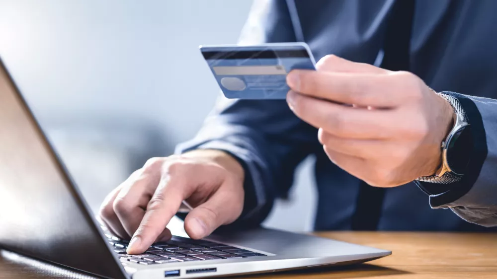 Safe online payment and electronic money transfer security. Pay with digital technology. Man using credit card and laptop to login to internet bank. Financial safety to prevent scam, threat and fraud.