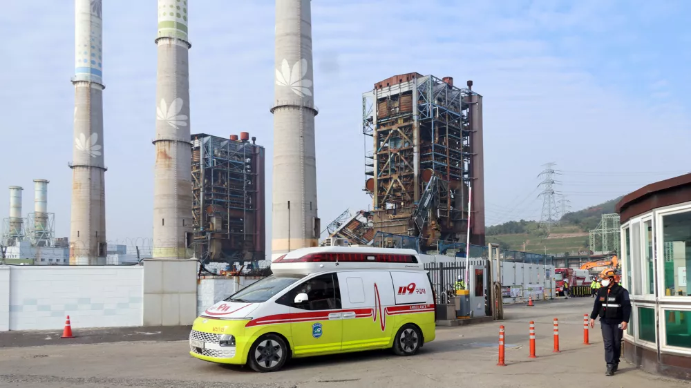 An ambulance carrying a victim leaves from the scene where a 60-meter (196-foot) tower collapsed during demolition work at a decommissioned thermal power plant in Ulsan, South Korea, Friday, Nov. 7, 2025. (Kim Keun-joo/Yonhap via AP)