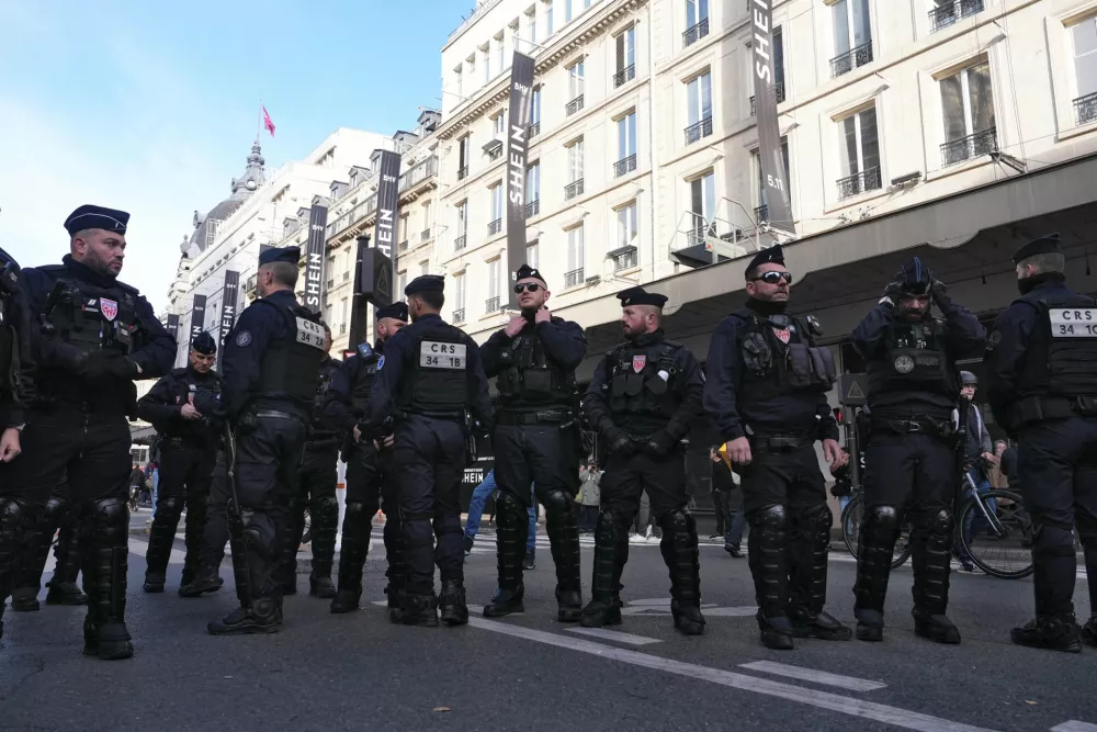05 November 2025, France, Paris: Riot police officers stand guard as people protest in front of the BHV department store in Paris on the opening day of Asian e-commerce giant Shein's first physical store outside the Bazar de l'Hotel de Ville (BHV) department store in Paris. France has temporarily suspended the operations of the low-cost online platform Shein after it was found to have been selling sex dolls with child-like features. Photo: Dimitar Dilkoff/AFP/dpa