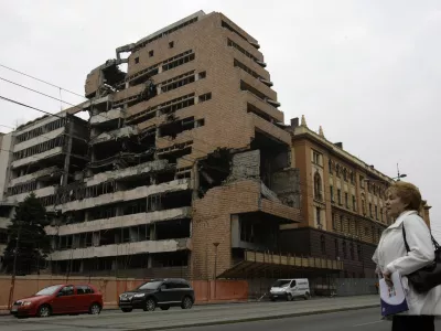 FILE- A woman walks in front of the destroyed former Serbian army headquarters in Belgrade, Serbia, March 24, 2010. Opposition groups in Serbia are planning protests against a real estate development project that will be financed by the firm of Donald Trump's son-in-law, Jared Kushner, at the site of the former Serbian army headquarters destroyed in a U.S.-led NATO bombing campaign in 1999. The Serbian government earlier this week signed a deal with a Kushner-related company for the 99-year lease of land in central Belgrade for the "revitalization" of the bombed-out buildings. (AP Photo/Darko Vojinovic, File)