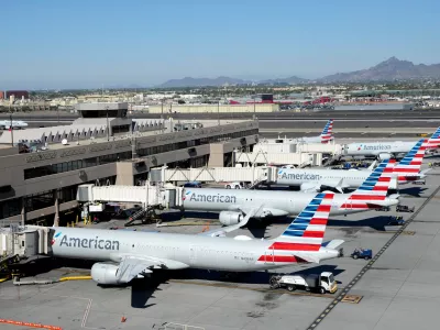 American Airlines jets sit parked at their jetways at Phoenix Sky Harbor International Airport Saturday, Nov. 8, 2025, in Phoenix. (AP Photo/Ross D. Franklin)