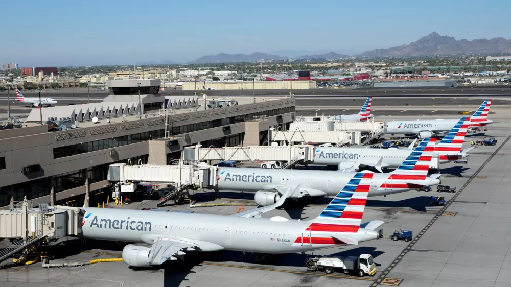 American Airlines jets sit parked at their jetways at Phoenix Sky Harbor International Airport Saturday, Nov. 8, 2025, in Phoenix. (AP Photo/Ross D. Franklin)