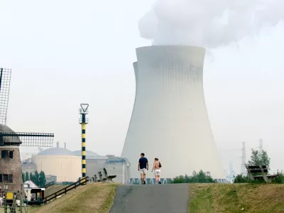 A couple walks toward the cooling towers of a nuclear power plant in Doel, Belgium, Thursday Aug, 7, 2003. With a sweltering heat wave continuing to blanket much of Europe, many nuclear power plants have had to consider reducing their production due to high temperatures on the cooling towers. (AP Photo/Virginia Mayo)