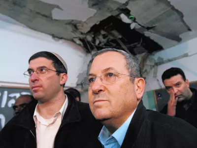 Israel's Defence Minister Ehud Barak (C) surveys a damaged classroom after a rocket landed in a school in the southern city of Beersheba December 31, 2008. Israel on Wednesday said the time was not right for a ceasefire in the Gaza Strip and stepped up preparations for a possible ground offensive after Hamas's long-range rockets hit another major population centre. At least four of the longer-range Grad rockets hit Beersheba, the city Israel calls the capital of the Negev, its southern region. One struck the school that was empty. REUTERS/Gil Cohen Magen (ISRAEL)------4 kolone