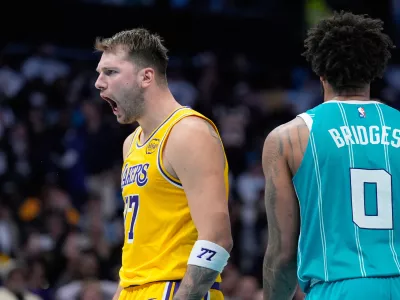 Los Angeles Lakers guard Luka Doncic celebrates after scoring as Charlotte Hornets forward Miles Bridges looks on during the second half of an NBA basketball game Monday, Nov. 10, 2025, in Charlotte, N.C. (AP Photo/Chris Carlson)