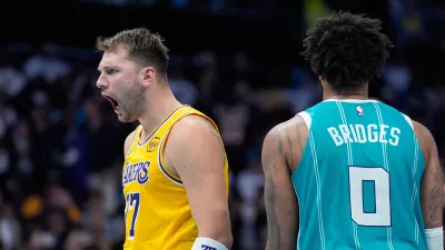 Los Angeles Lakers guard Luka Doncic celebrates after scoring as Charlotte Hornets forward Miles Bridges looks on during the second half of an NBA basketball game Monday, Nov. 10, 2025, in Charlotte, N.C. (AP Photo/Chris Carlson)