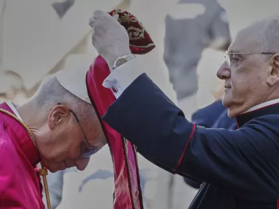 Pope Leo XIV is helped by Monsignor Leonardo Sapienza to wear a stole at the foot of Capitoline Hill, in Rome, Sunday, May 25, 2025. (AP Photo/Riccardo De Luca)
