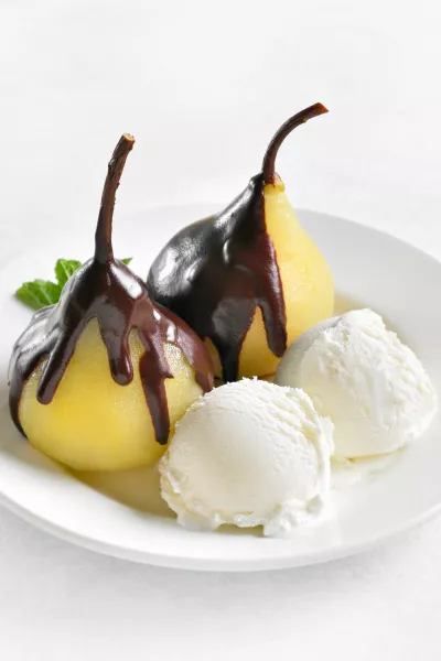 Poached pears with chocolate sauce and ice cream on white background. Close up view / Foto: Tatiana Volgutova