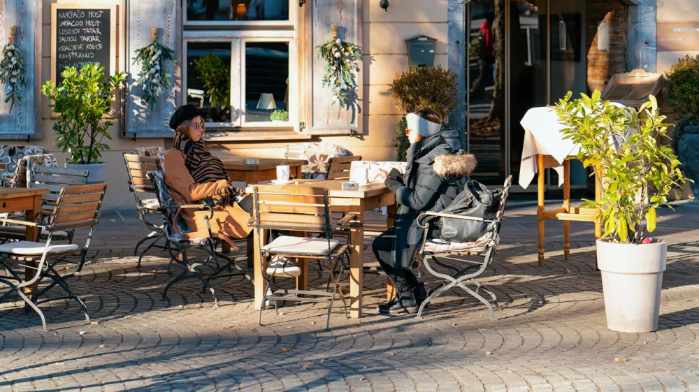 Ljubljana, Slovenia - January 15, 2019: Young women eating and drinking in restaurants, tables and chairs in Ljubljana old town embankment, Slovenia. Ladies in open air cafes in Slovenian capital city / Foto: Romanbabakin, Getty Images