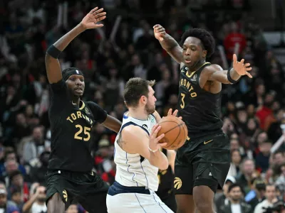 Nov 26, 2022; Toronto, Ontario, CAN; Dallas Mavericks guard Luka Doncic (77) controls the ball against Toronto Raptors forward Chris Boucher (25) and forward OG Anunoby (3) in the second half at Scotiabank Arena. Mandatory Credit: Dan Hamilton-USA TODAY Sports / Foto: Dan Hamilton