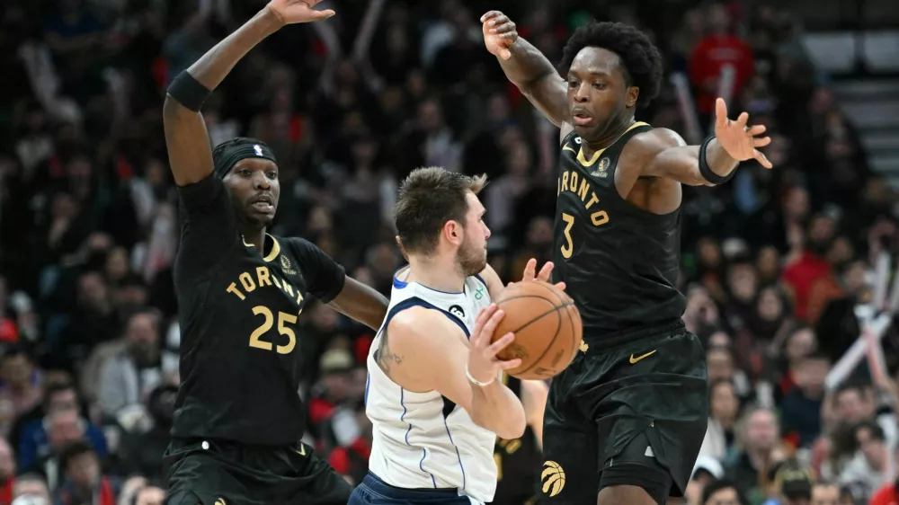 Nov 26, 2022; Toronto, Ontario, CAN; Dallas Mavericks guard Luka Doncic (77) controls the ball against Toronto Raptors forward Chris Boucher (25) and forward OG Anunoby (3) in the second half at Scotiabank Arena. Mandatory Credit: Dan Hamilton-USA TODAY Sports / Foto: Dan Hamilton