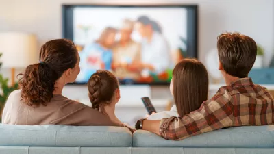 Happy family spending time together. Mother, father and children watching TV, movies with popcorn in the evening at home. / Foto: Choreograph