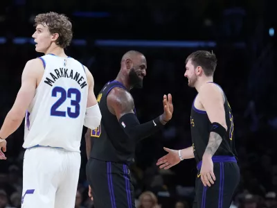 Nov 18, 2025; Los Angeles, California, USA; Los Angeles Lakers forward LeBron James (center) and guard Luka Doncic (77) react as Utah Jazz forward Lauri Markkanen (23) watches in the fourth quarter at Crypto.com Arena. Mandatory Credit: Kirby Lee-Imagn Images