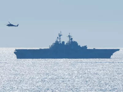 A helicopter flies past the USS Boxer (LHD 4), a Wasp-class amphibious assault ship, as it takes part in training off the coast of California near Camp Pendleton, California, U.S., October, 16, 2025.  REUTERS/Mike Blake