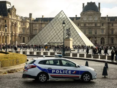 FILE - A police car parks in the courtyard of the Louvre museum, one week after the robbery, on Oct. 26, 2025, in Paris. (AP Photo/Thomas Padilla, File)