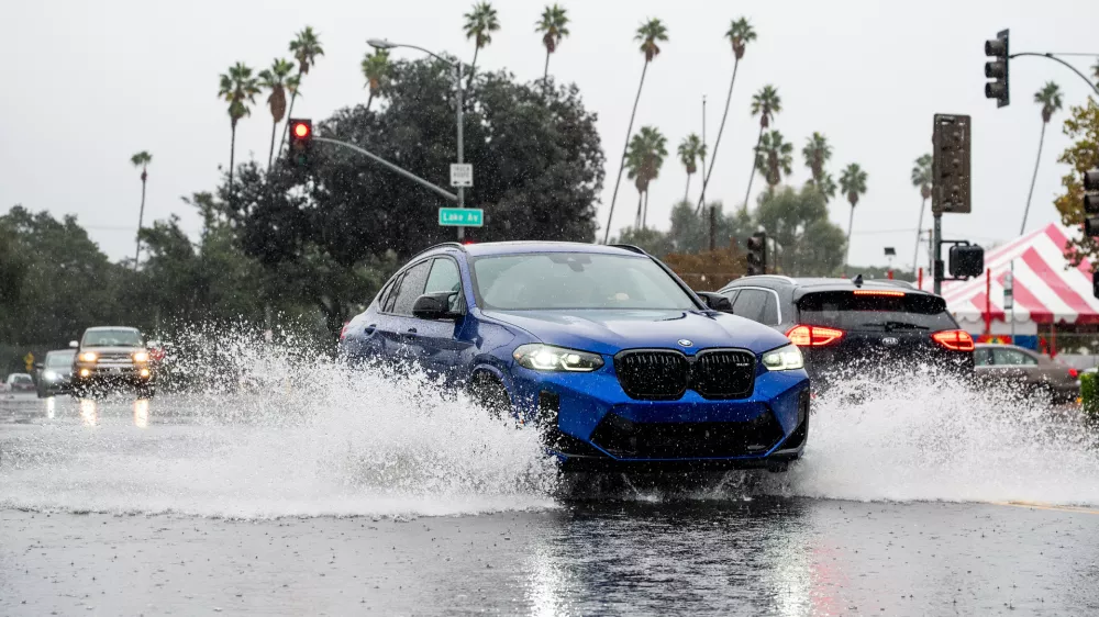 A vehicle crosses a flooded roadway in Pasadena, Calif., on Saturday, Nov. 15, 2025. (AP Photo/Noah Berger)