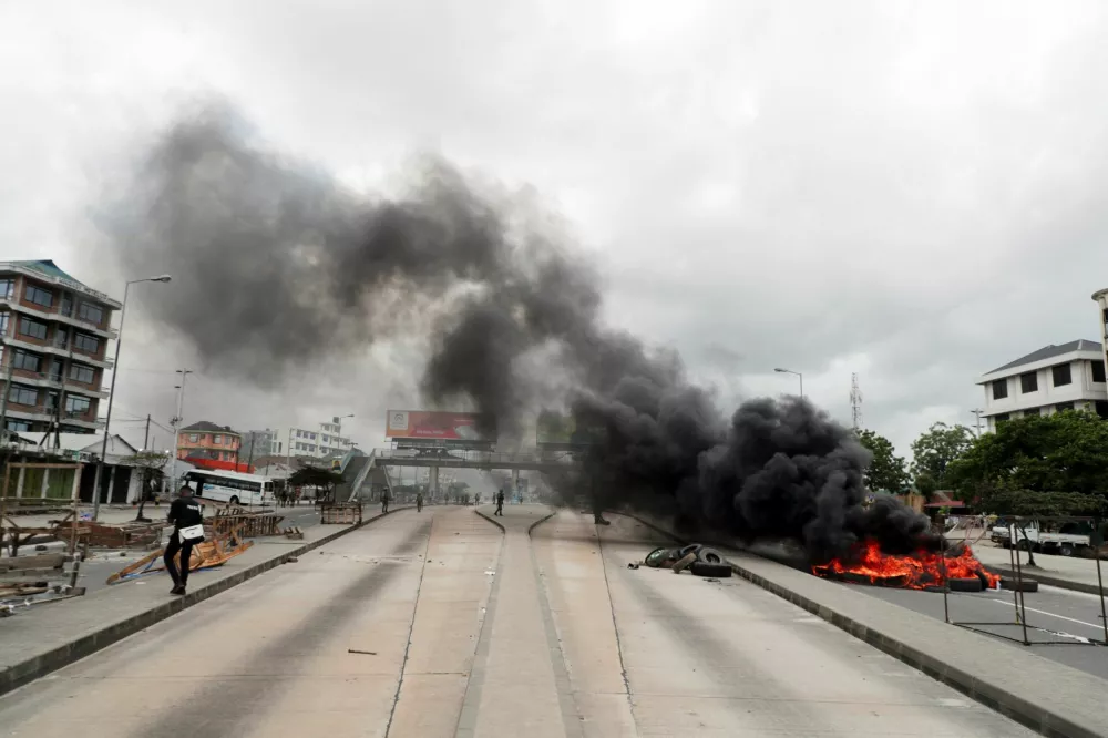 Tyres burn along a deserted road during violent protests that marred the election following the disqualification of the two leading opposition candidates in Dar es Salaam, Tanzania, October 29, 2025. REUTERS/Onsase Ochando