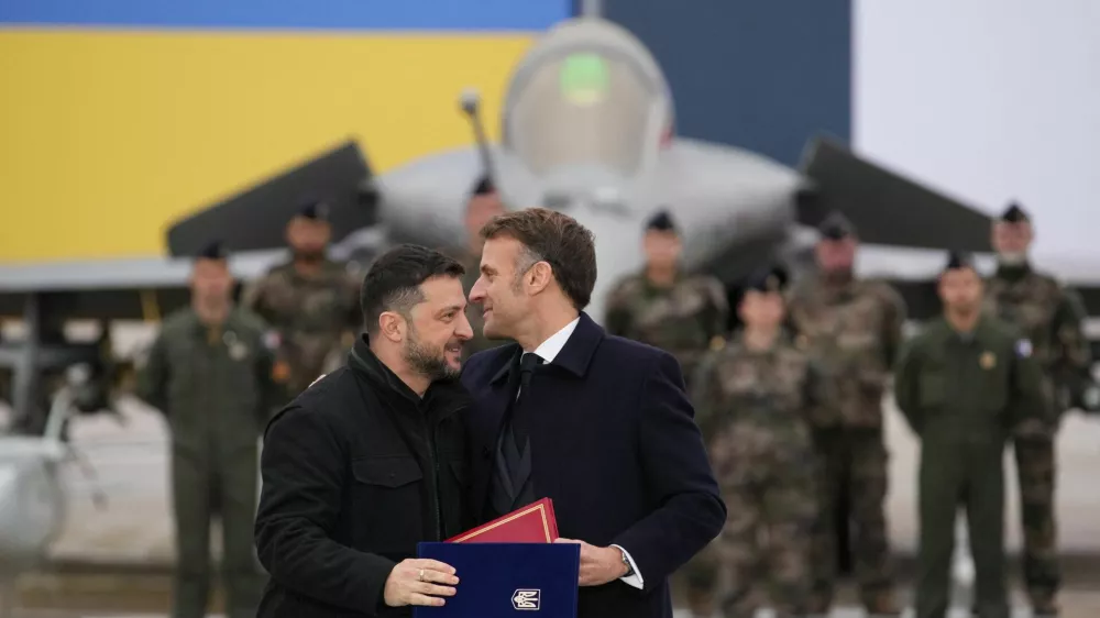 French President Emmanuel Macron and Ukrainian President Volodymyr Zelenskiy hug after signing an agreement at the Villacoublay air base near Paris, France, November 17, 2025. Christophe Ena/Pool via REUTERS