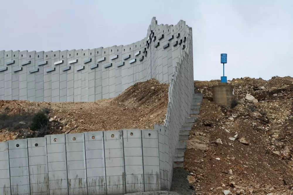 A "Blue Line" marker stands near a concrete wall along Lebanon's southern border which, according to the Lebanese presidency, extends beyond the "Blue Line", a U.N.-mapped line separating Lebanon from Israel and the Israeli-occupied Golan Heights, as seen from northern Israel, November 16, 2025. REUTERS/Shir Torem