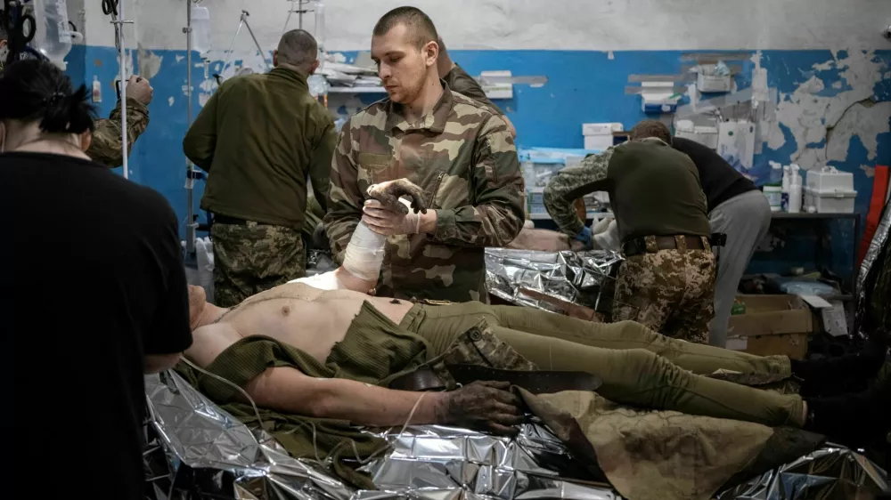 Medics treat wounded Ukrainian soldiers inside a frontline medical stabilisation point, amid Russia's attack on Ukraine, near Vuhledar, Donetsk region, Ukraine, February 19, 2023. Nearly a year into Russia's invasion, fighting now amounts to attritional duels of artillery and infantry assaults, with neither side making significant gains. The costs of that deadly grind are clear to the team of medics and nurses as it toils away, hemmed in by racks of medical supplies and portable heaters, at this stabilisation point in the Donetsk region where battles are fierce. REUTERS/Marko Djurica   SEARCH "DJURICA UKRAINE MEDICS" FOR THIS STORY. SEARCH "WIDER IMAGE" FOR ALL STORIES. TPX IMAGES OF THE DAY