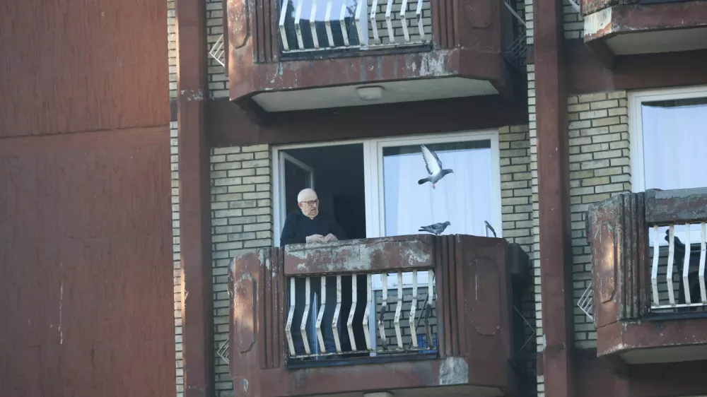 A man at an elderly people's home feeds pigeons, in an undamaged part of the building after a fire at the elderly people's home, in the town of Tuzla, Bosnia and Herzegovina, November 5, 2025. REUTERS/Amel Emric
