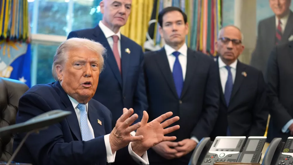 President Donald Trump answers questions from reporters during a meeting with the White House task force on the 2026 FIFA World Cup in the Oval Office of the White House, Monday, Nov. 17, 2025, in Washington, as FIFA President Gianni Infantino, Secretary of State Marco Rubio and FIFA senior adviser Carlos Cordeiro listen. (AP Photo/Evan Vucci)