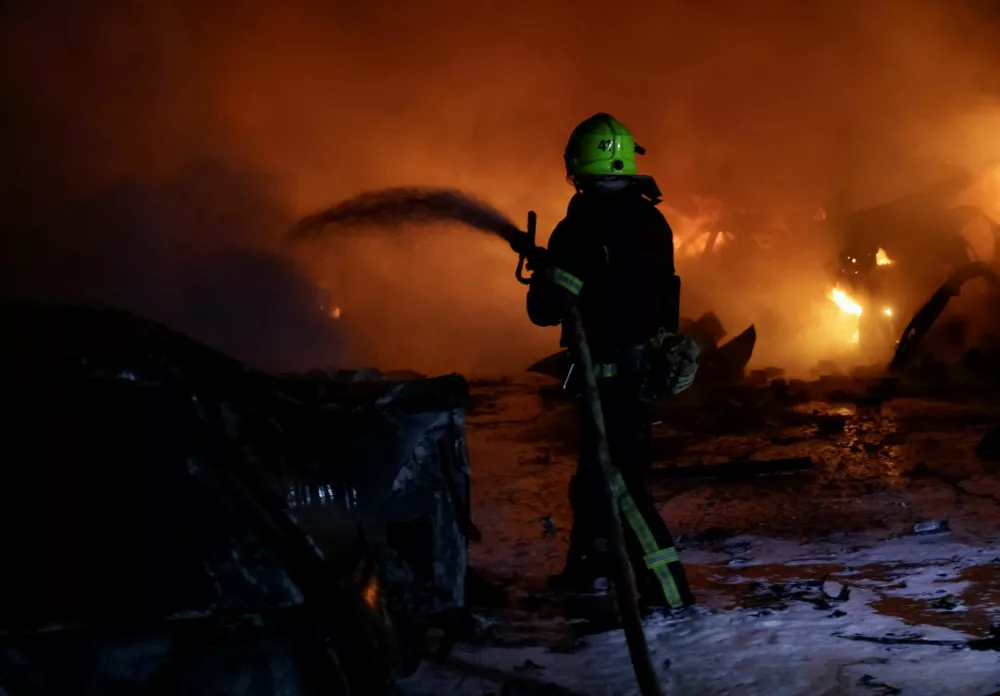 A firefighter puts out the fire in burning cars near the apartment building hit by a Russian drone strike, amid Russia's attack on Ukraine, in Kharkiv, Ukraine November 19, 2025. REUTERS/Sofiia Gatilova
