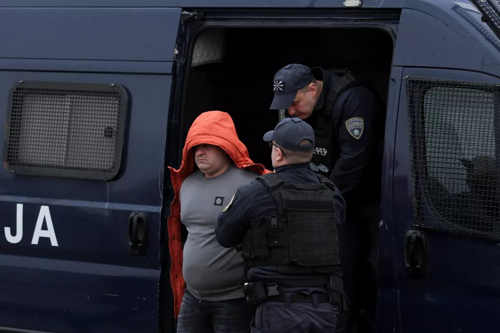 North Macedonian police escort one of the suspects over deadly Kocani nightclub fire at the courthouse in Idrizovo, North Macedonia, November 19, 2025. Thirty seven people have been charged in connection with the fatal disco fire in Kocani in March, which killed 63 people. REUTERS/Valdrin Xhemaj