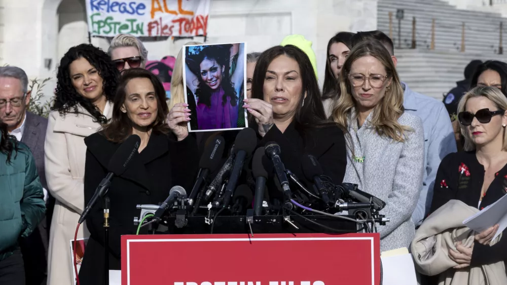 18 November 2025, US, WashingtonEpstein abuse survivor Haley Robson holds up a photo of her younger self during a news conference on the Epstein Files Transparency Act outside the US Capitol in Washington. PhotoMehmet Eser/ZUMA Press Wire/dpa