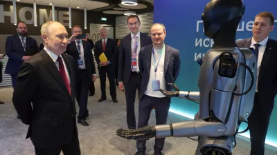 Russian President Vladimir Putin, left, looks at a humanoid robot with built-in Sberbank's GigaChat as he visits an exhibition of the AI Journey 2025, an international conference on artificial intelligence and machine learning, at the Sberbank City business complex in Moscow, Russia, Wednesday, Nov. 19, 2025. (Vyacheslav Prokofyev, Sputnik, Kremlin Pool Photo via AP)