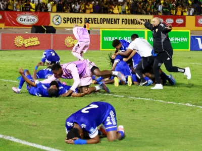 Soccer Football - FIFA World Cup - CONCACAF Qualifiers - Group B - Jamaica v Curacao - National Stadium Independence Park, Kingston, Jamaica - November 18, 2025 Curacao coach Dean Gorre and players celebrate after they qualify for the World Cup REUTERS/Gilbert Bellamy