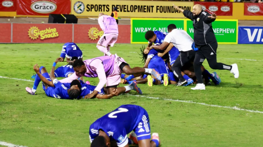 Soccer Football - FIFA World Cup - CONCACAF Qualifiers - Group B - Jamaica v Curacao - National Stadium Independence Park, Kingston, Jamaica - November 18, 2025 Curacao coach Dean Gorre and players celebrate after they qualify for the World Cup REUTERS/Gilbert Bellamy