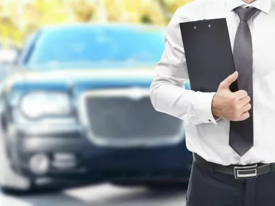 2BFPPNW Insurance agent with clipboard and car on background