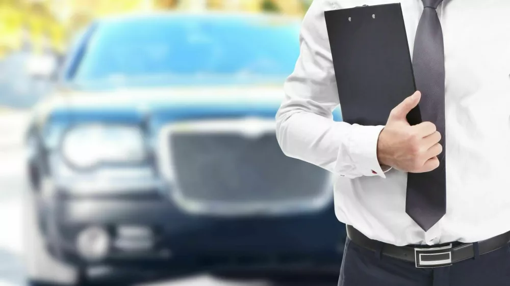 2BFPPNW Insurance agent with clipboard and car on background