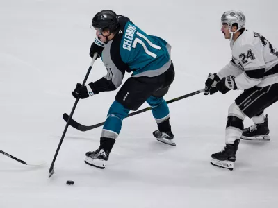 San Jose Sharks center Macklin Celebrini (71) passes the puck while defended by Los Angeles Kings center Phillip Danault (24) during the second period of an NHL hockey game, Thursday, Nov. 20, 2025, in San Jose, Calif. (AP Photo/Godofredo A. Vásquez)
