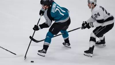 San Jose Sharks center Macklin Celebrini (71) passes the puck while defended by Los Angeles Kings center Phillip Danault (24) during the second period of an NHL hockey game, Thursday, Nov. 20, 2025, in San Jose, Calif. (AP Photo/Godofredo A. V&aacute;squez)