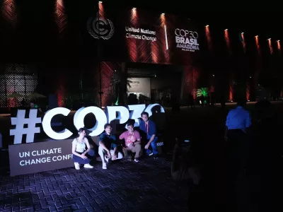 People pose for photos outside the venue for the COP30 U.N. Climate Summit, Friday, Nov. 21, 2025, in Belem, Brazil. (AP Photo/Joshua A. Bickel)