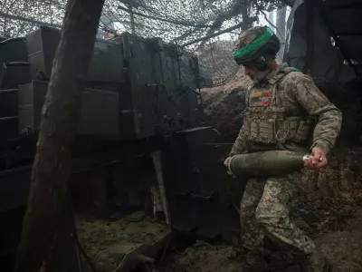 A serviceman of the 38th Separate Marine Brigade of the Ukrainian Armed Forces carries a shell for a M109A5 self-propelled howitzer as he prepares to fire towards Russian troops at a position in a front line, amid Russia's attack on Ukraine, near the frontline town of Pokrovsk in Donetsk region, Ukraine November 21, 2025. REUTERS/Anatolii Stepanov